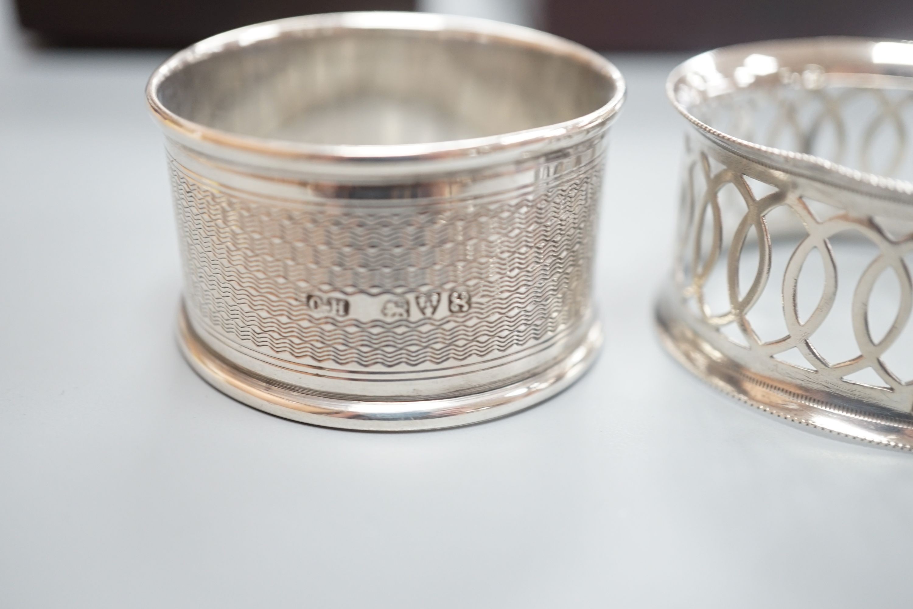 A cased pair of George V engine turned silver napkin rings, by Charles Horner, Chester, 1923 and an Edwardian cased pair of silver napkin rings.